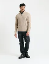 Sweater de punto inglés color verde, con cuello alto y cierre frontal parcial metálico. Diseño de manga larga con puños y ruedo acanalados.
