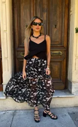 Top negro de lino y viscosa, con breteles finos y corte cruzado con volado lateral. Se ata y regula en la espalda.