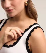 Blusa musculosa de viscosa color blanco, con escote redondo y detalles de ondas en contraste negro en el cuello y los breteles.