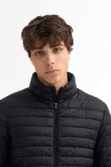 Campera puffer de cuello alto con cierre frontal, diseño acolchado horizontal y ajuste estándar.