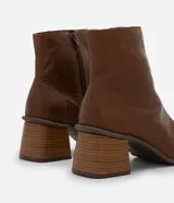Bota de caña media Satinato confeccionada en cuero color marrón, con diseño de punta cuadrada y tacón bloque mediano.