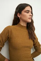 Polera color beige de tejido tramado, con cuello alto y bordado en el cuello, corte ajustado.