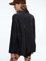 Chaqueta de corte recto y silueta cómoda, con cierre frontal de botones y bolsillos delanteros. Presenta un diseño estampado con efecto tie-dye en tonos negro y blanco.