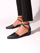 Zapato de cuero color caramelo, con punta fina y tiras cruzadas con hebilla que estilizan el pie y aseguran un calce firme. Su pequeño taco bajo brinda altura justa para el día a día, sin renunciar al confort.