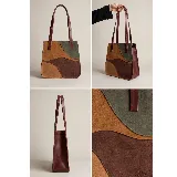 Cartera tipo tote de diseño patchwork, confeccionada en gamuza combinada en tonos tostado, marrón, bordó y verde. Cuenta con doble asa de hombro y detalles de cuero liso en los bordes.
