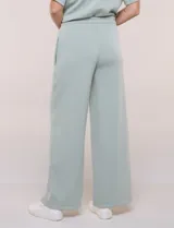 Conjunto de buzo de manga corta con hombros caídos y escote redondo, acompañado de un pantalón tipo wide leg de tiro alto con cintura elástica y cordón de ajuste, en color verde.