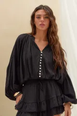 Short pollera negro de tiro alto, confeccionado en tejido texturizado con cintura elástica ajustable mediante cordón, diseño de doble volado y detalles de encaje en los bordes.