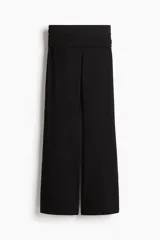 Pantalón negro de punto de algodón suave, con cintura ancha plegable y piernas rectas de corte acampanado.