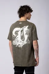 Remera de corte holgado con efecto de lavado ácido en tono gris oscuro. Presenta un pequeño estampado gráfico en el centro del pecho con la inscripción 'ASTRAL ENERGY' y las siglas 'VCP'.