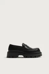Mocasín negro de estilo casual, con detalle de antifaz en el empeine, horma redonda y suela gruesa track con volumen.