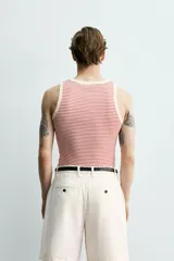 Camiseta sin mangas de corte regular, confeccionada en tejido de algodón con elasticidad. Presenta un diseño de rayas horizontales finas, cuello redondo y acabados en vivo doble.