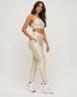 Calza deportiva de talle alto color beige metalizado, con diseño anatómico y bolsillo lateral.
