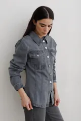 Chaqueta de denim color marrón, con corte entallado en la cintura, cierre frontal con botones metálicos y bolsillos superiores con solapa.