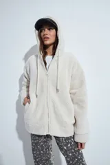 Canguro de corderito con capucha, cierre frontal y bolsillos laterales. Diseño relajado y textura suave.