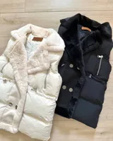 Chaleco puffer blanco con cuello de piel sintética y cierre con broches metálicos.
