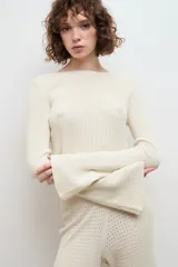 Blusa color crema de punto 100% algodón, con cuello redondo y mangas largas acampanadas.