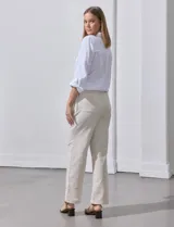 Pantalón de lino de corte recto y tiro medio, con pretina elástica ancha y lazo de ajuste frontal. Presenta bolsillos laterales verticales y bolsillos traseros.