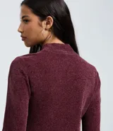 Blusa de manga larga confeccionada en tejido de chenille, con cuello alto y ajuste al cuerpo.