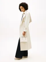 Cartera tote de poliuretano color blanco con acabado texturizado y motivo integral del monograma TH en bajo relieve. Cuenta con dos asas superiores, correa cruzada extraíble y detalles metálicos dorados, incluyendo el monograma TH en la parte delantera.