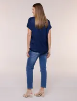 Blusa azul marino de silueta relajada confeccionada en satén, con escote redondo, hombros caídos y mangas cortas de corte japonés con puño doblado.