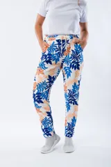 Pantalón babucha blanco con estampado de hojas en azul y naranja, con cintura elástica y cordón ajustable.