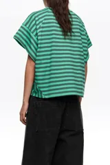 Remera corta de corte amplio confeccionada en 100% algodón, con diseño a rayas horizontales azules y negras, escote redondo, mangas cortas caídas y pequeño logo bordado en el pecho.