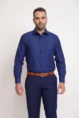 Camisa de vestir de manga larga en color azul marino, con cuello clásico y cierre frontal de botones. Presenta un corte entallado que se adapta a la silueta.