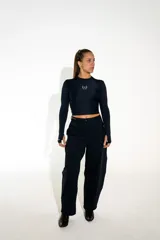 Pantalón sastrero de corte recto y tiro alto, confeccionado en lycra de color negro. Presenta cierre frontal con botón, bolsillos laterales y un diseño que combina la estructura de la sastrería con la comodidad de un tejido elástico.