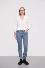 Pantalon jean de corte skinny y tiro alto, con diseño clásico de cinco bolsillos y cierre frontal con botón y cremallera.