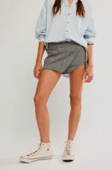 Falda pantalón corta con estampado de cuadros vichy en blanco y negro, diseño cruzado al frente y short interno.