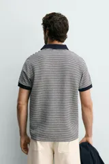 Chomba de punto con diseño de micro rayas horizontales en color azul marino y blanco, con cuello solapa y puños en contraste.