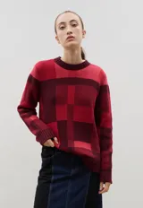 Sweater de cuello redondo con ajuste holgado, confeccionado en tejido de punto de algodón con diseño jacquard a cuadros en tonos rojos y bordó.