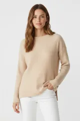 Sweater de viscosa color beige claro, de tejido acanalado vertical, con cuello redondo y manga larga.