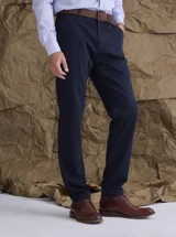 Pantalón de gabardina color azul marino, de corte recto y estilo clásico, con cierre de botón y cremallera, y trabillas para cinturón.