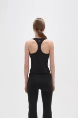 Musculosa deportiva de poliamida, color negro, con cuello cuadrado y breteles anchos. Diseño ajustado al cuerpo con costuras laterales visibles.