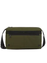Cartera tipo mensajera de color verde militar confeccionada en nailon con acabado texturizado. Presenta un diseño utilitario con una raya negra a contraste en la parte delantera y el logo metálico de Tommy Hilfiger. Cuenta con un compartimento principal y un bolsillo exterior frontal, ambos con cierre de cremallera, además de una correa ajustable negra.