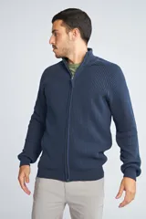 Campera tejida de algodón con cierre frontal completo, cuello alto y mangas largas con puños acanalados. Presenta un diseño de punto acanalado vertical y un pequeño logo bordado en el ruedo.