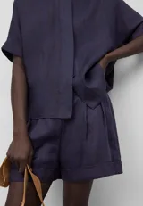 Bermuda corta de ramio a rayas verticales en tonos azul y rojo. Presenta cinturilla elástica en la espalda, pinzas en el delantero, bolsillos laterales y bajo con vuelta.