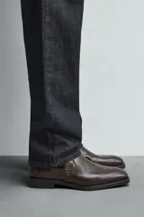 Bota marrón de cuero con estampado de cocodrilo, corte a la altura del tobillo, punta fina y cierre lateral con cremallera.