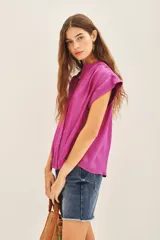 Camisa de corte amplio y mangas cortas, con cuello mao y cierre frontal de botones. Confeccionada en tejido fluido con acabado satinado.