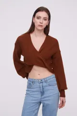 Sweater negro de tejido de punto con diseño cruzado en el frente, escote en V profundo y mangas largas con puños ajustados.