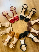 Sandalias de tacón cuadrado medio, con diseño de tiras finas y cierre de pulsera ajustable al tobillo. Confeccionadas en cuero sintético, presentan una punta cuadrada y un estilo minimalista y versátil.