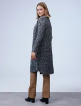Cardigan largo de tejido boucle color negro con detalles en blanco y gris.
