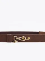 Cinturón negro confeccionado en cuero vacuno con un segmento elastizado, cierre de mosquetón metálico dorado y detalle de dije con diseño de abeja.