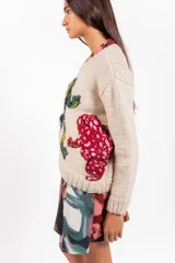 Sweater de lana merino color beige, tejido a mano con diseño holgado, cuello redondo y bordados artesanales de ranas y detalles coloridos.