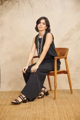 Pantalón de vestir negro de corte ancho y tiro alto, con diseño pinzado en la cintura.