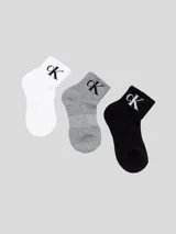 Pack de tres pares de medias tobilleras de mujer, una blanca, una gris jaspeada y una negra, todas con el logo de Calvin Klein en negro o blanco en el tobillo.