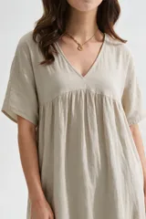 Vestido midi marrón de corte holgado, con escote en V, mangas cortas y detalle de volados fruncidos en el pecho y en el ruedo.