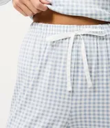 Pantalón de pijama modelo jogger con estampado de cuadros vichy en tonos celestes y blancos. Presenta cintura elástica y puños en los tobillos para mayor comodidad.