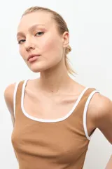 Top de canalé color tostado con ribetes blancos en el cuello y las sisas, de corte ajustado y sin mangas.